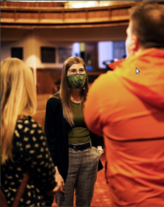 Karleigh Csordas wearing a mask listens to two constituents